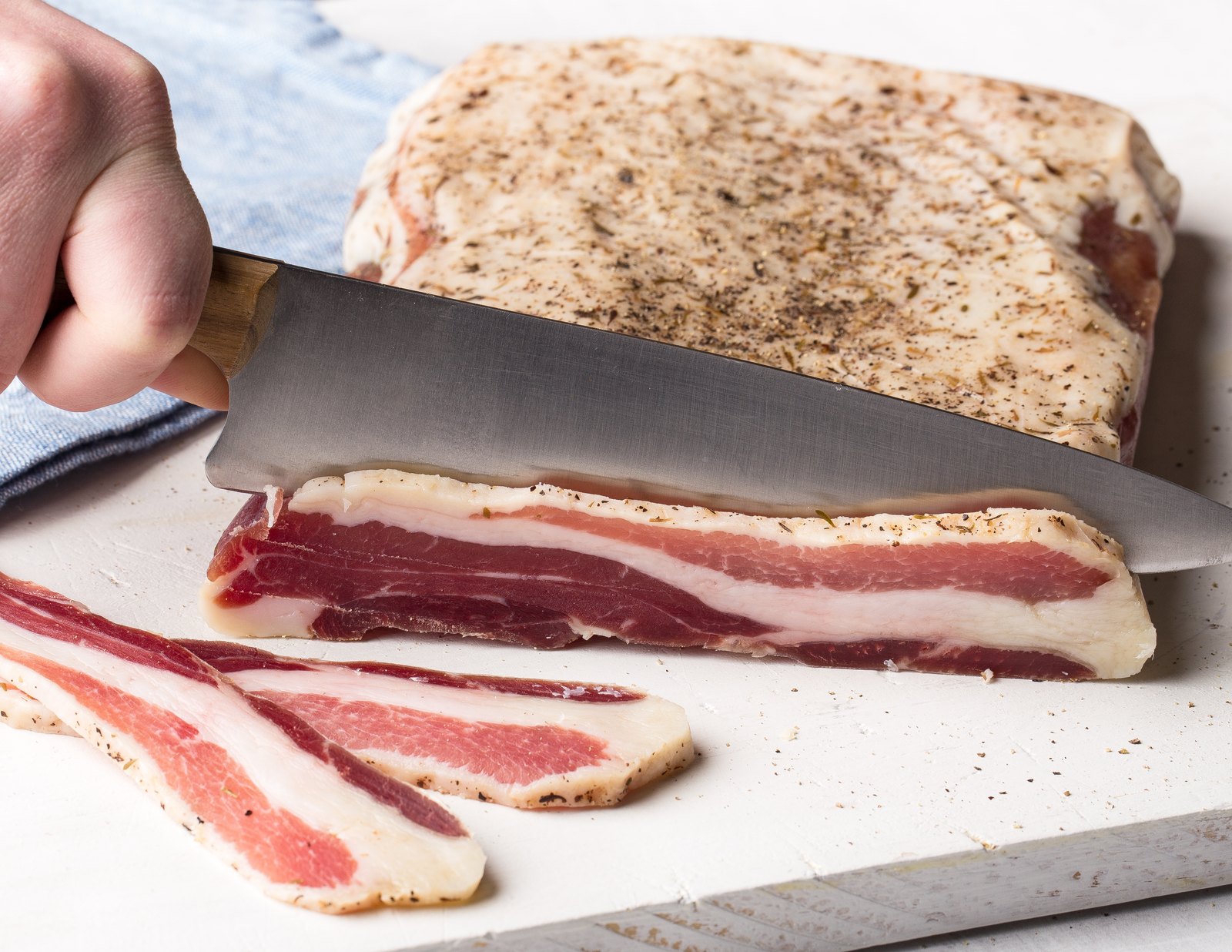 Pancetta being sliced by hand